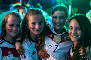 Vier Schülerinnen in Deutschland-Trikots lächeln in die Kamera